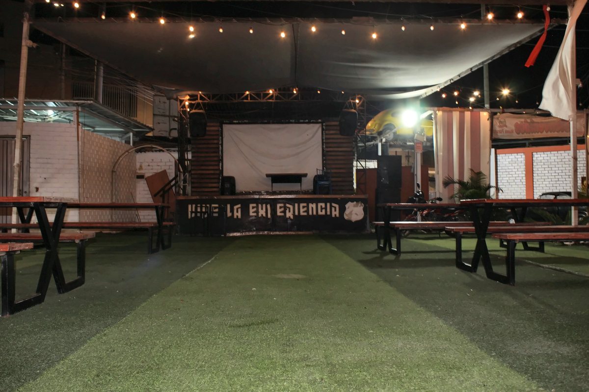 El escenario de La Premier, con el letrero «Vive la experiencia», frente a las mesas del patio
